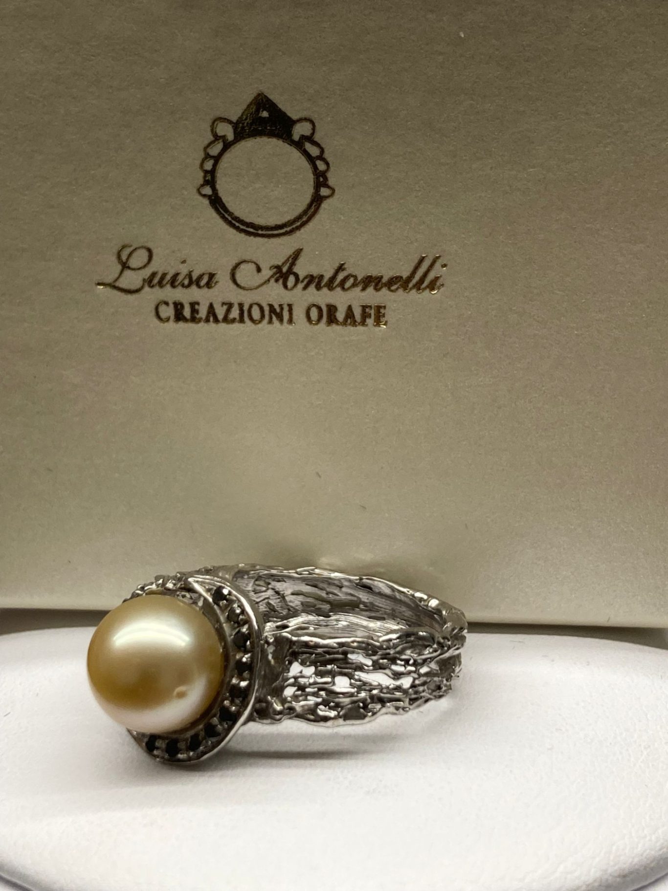 Anello in oro bianco 18KT con pavé di diamanti neri e perla gialla